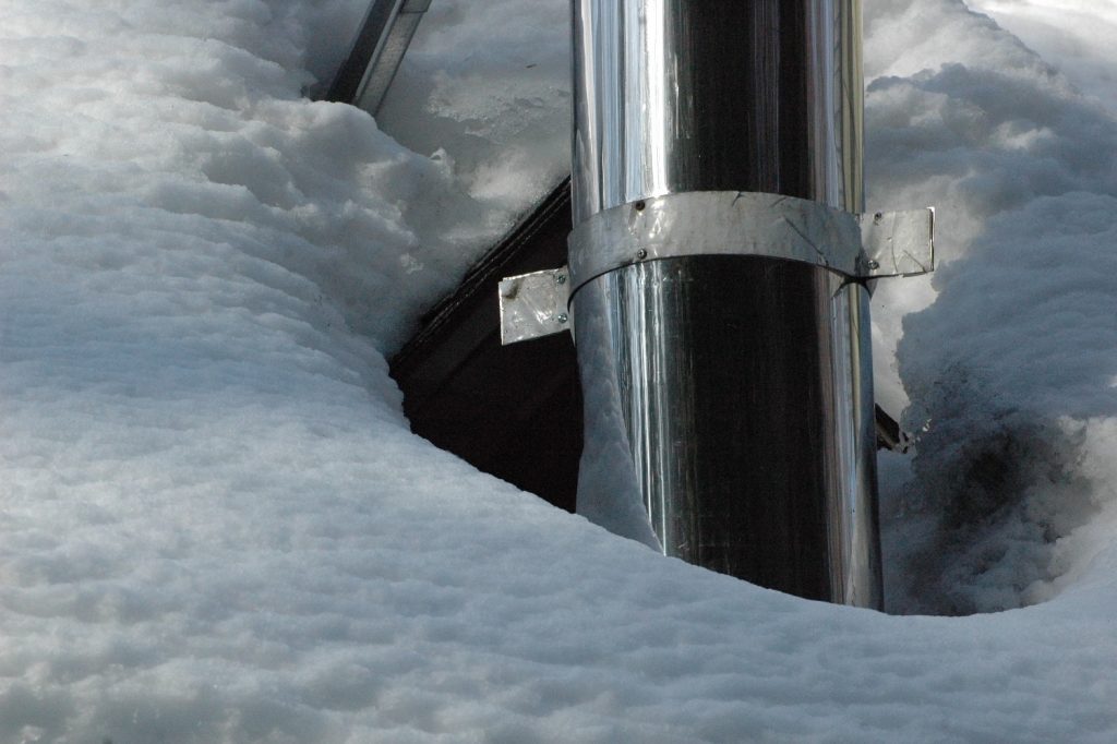 Photo BEBEXPERTS glace neige sur la toiture. Infiltration d'eau dans le toit par la cheminée.